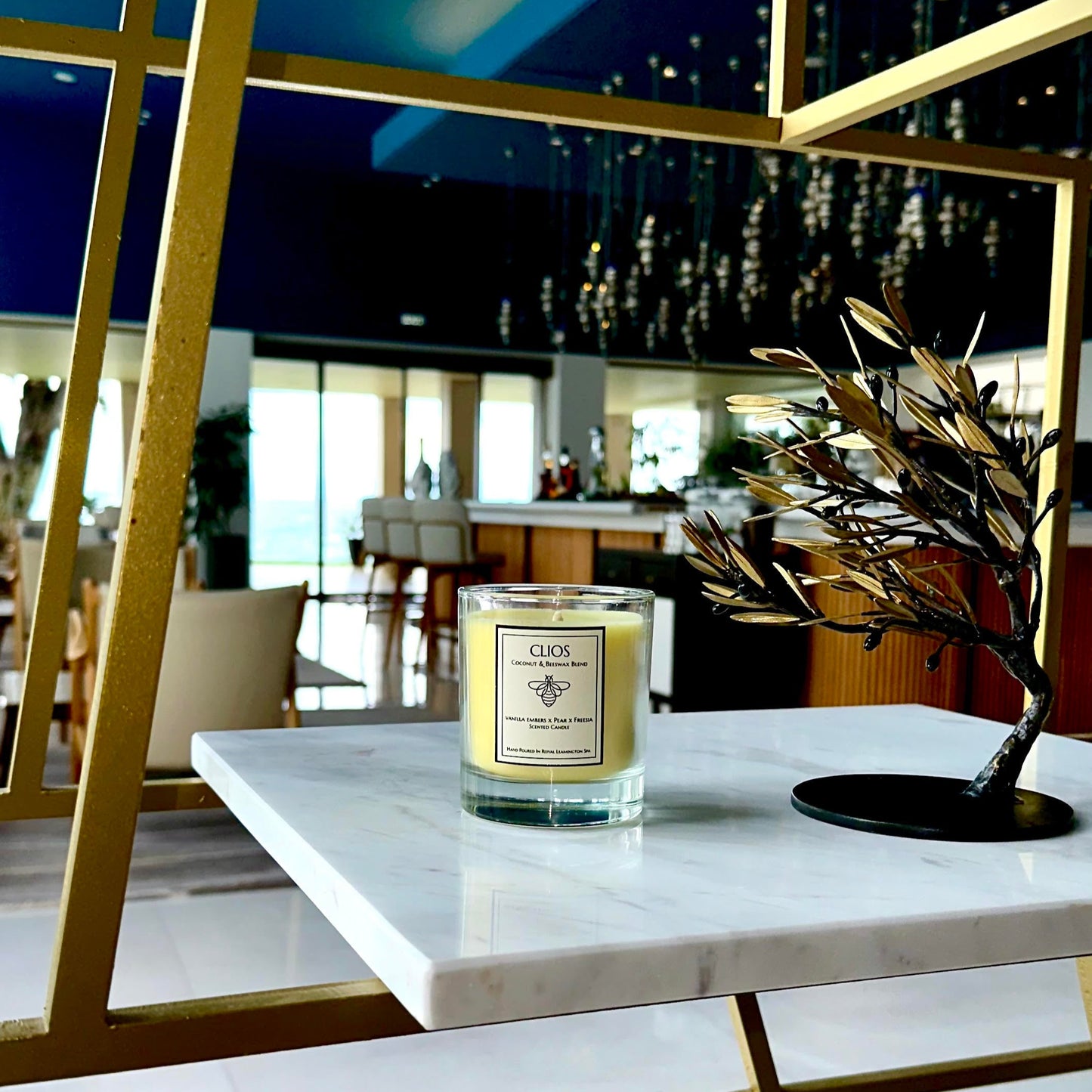 "Clios Golden Hour candle – luxury coconut and beeswax blend with vanilla embers, pear & freesia – displayed on marble shelf in a modern, upscale interior with gold accents – clean burn, hand-poured in Royal Leamington Spa."