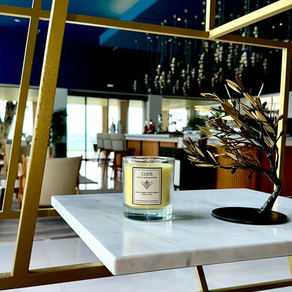 "Clios Golden Hour candle – luxury coconut and beeswax blend with vanilla embers, pear & freesia – displayed on marble shelf in a modern, upscale interior with gold accents – clean burn, hand-poured in Royal Leamington Spa."

